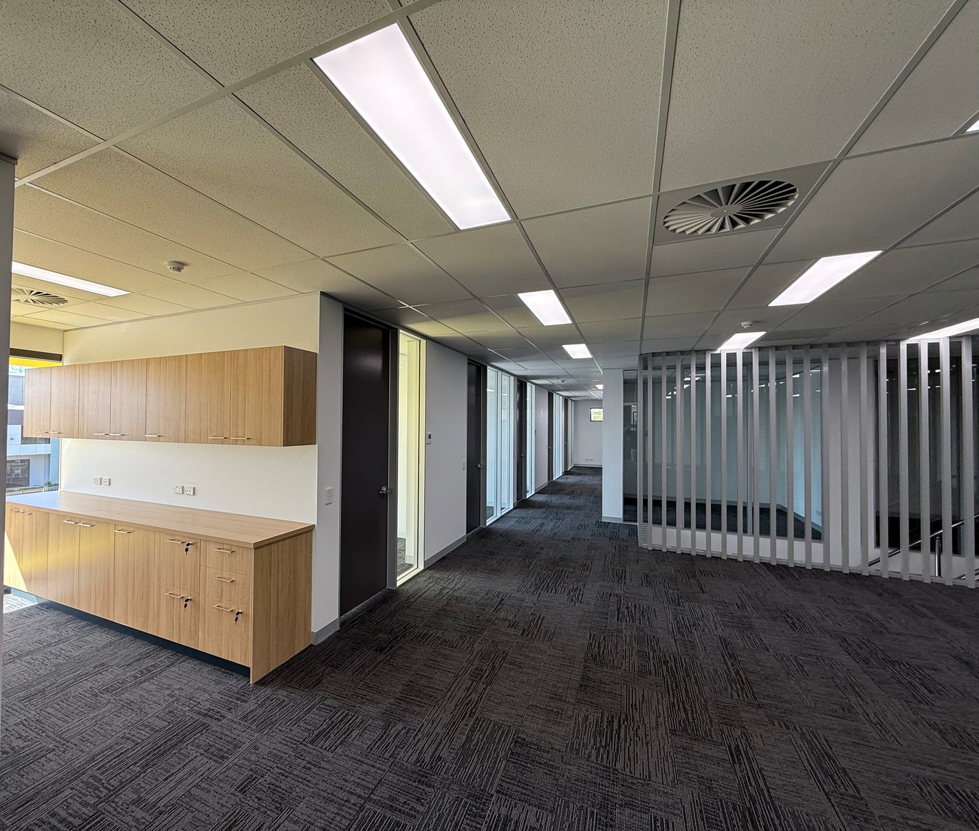 Completed commercial office fit-out with suspended grid ceilings and partitions